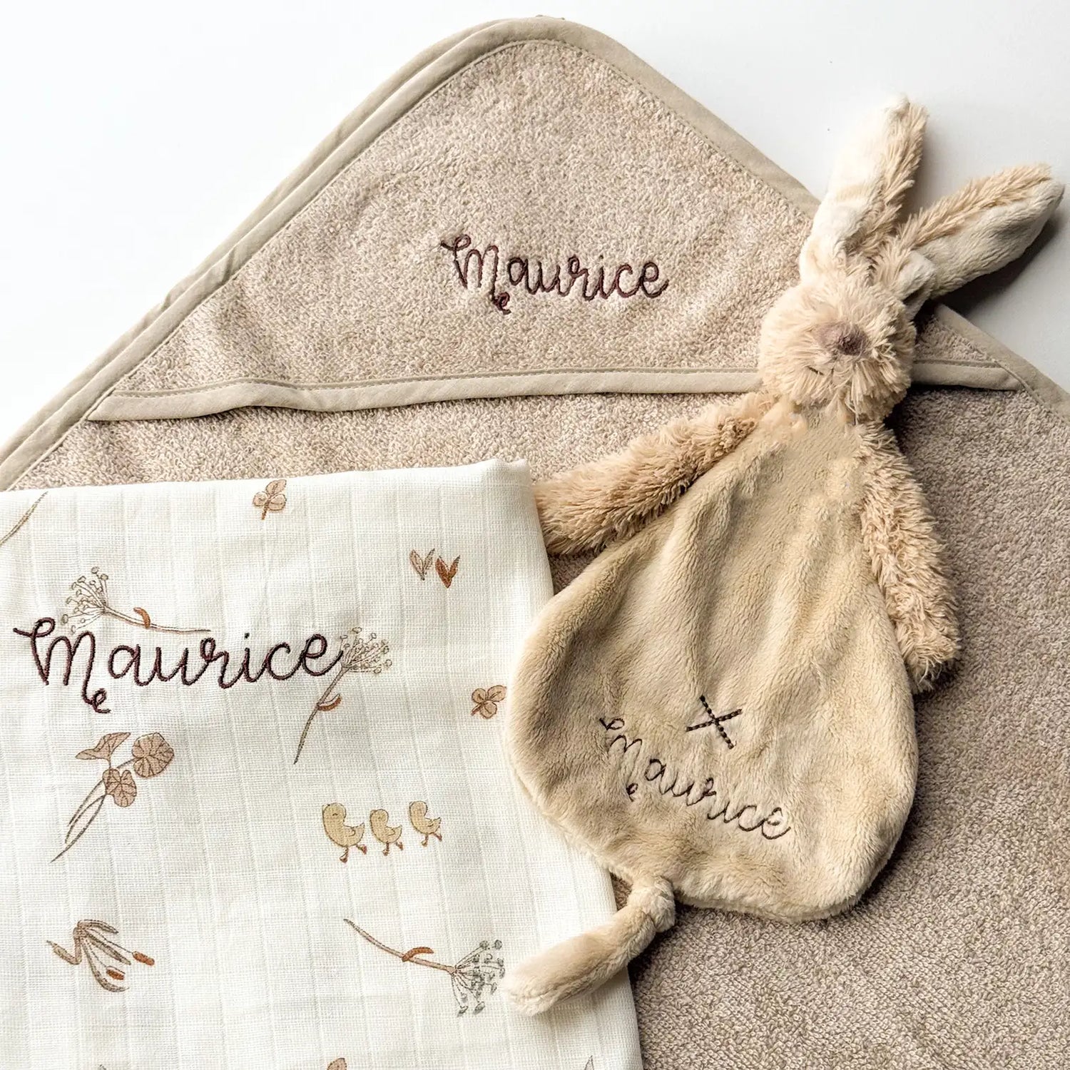 Een cadeaupakket voor baby Maurice. Het pakket bestaat uit een geborduurd knuffeltje, een geborduurde hydrofiele doek van Jollein en een badcape uit de collectie van Jollein gepersonaliseerd met naam.