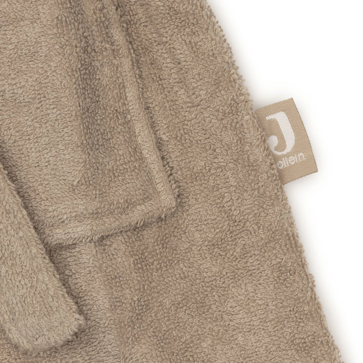 Detail van de afgewerkte rand met het Jollein-label op de Jollein badjas Milky Coffee