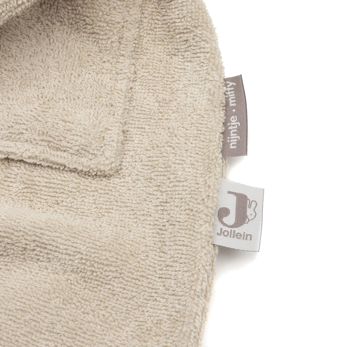 Detail van de afgewerkte rand met het Jollein-label op de Jollein badjas nijntje Warm Sand