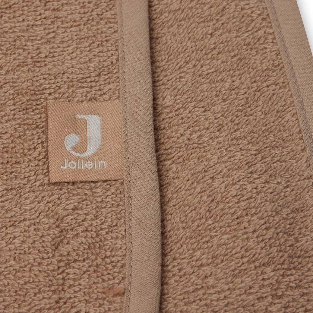Detail van de afgewerkte rand met het Jollein-label op de Jollein badponcho Biscuit