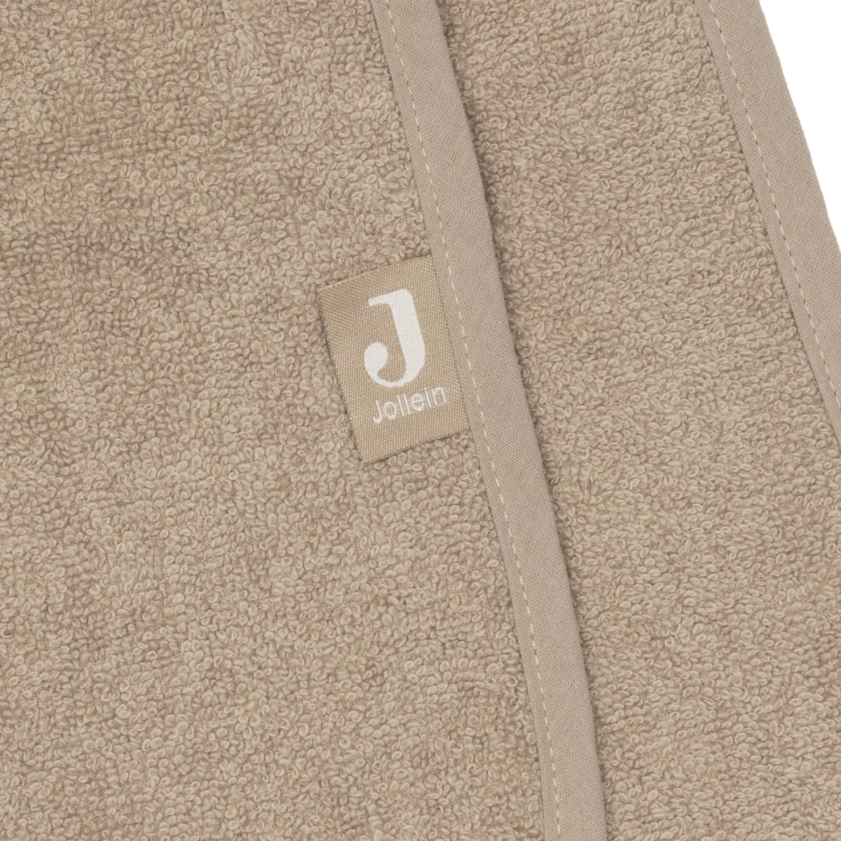 Detail van de afgewerkte rand met het Jollein-label op de Jollein badponcho Milky Coffee