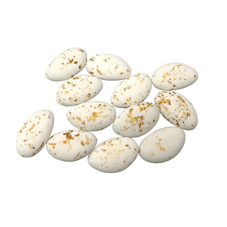 Een verzameling marmeren suikerbonen in de kleur goud, stijlvol gepresenteerd als doopsuiker.